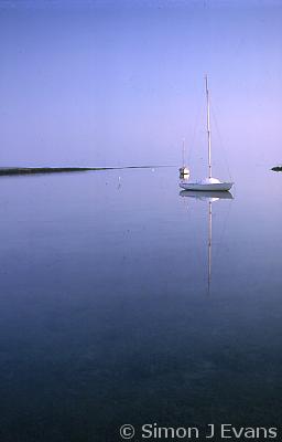 A yacht moored in a calm pool at Rhosneigr, Anglesey